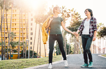 Happy lesbian couple having fun dating outdoor - Young gay women walking and holding hands outside - Lgbt, homosexuality, tolerance, equality and people relationship lifestyle concept