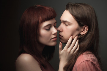 Young couple in love on the black background. Low key