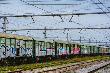 Abandoned train station with graffiti train with clear blue sky.
