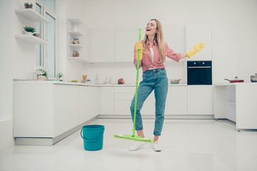 Full length body size photo beautiful busy nice duties she her lady wash white floor funky housemaid karaoke day singing mop crazy wear jeans denim casual plaid checkered shirt bright light kitchen