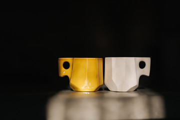 Ceramic cup for coffee on the table. Right is unfinished, left is ready