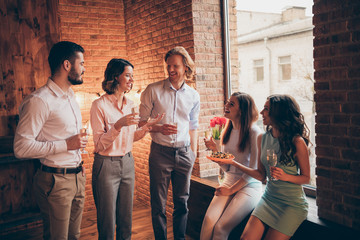 Company of nice attractive pretty classy cheerful positive guys ladies having fun talking romantic atmosphere every year Easter day tradition custom in industrial loft interior room indoors