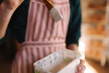 Close up of potter's hands making ornament on ceramic product. Plate in male's hands. Young artist