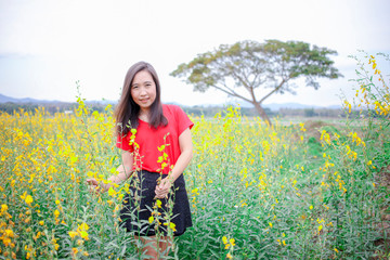 Fototapeta premium Pretty asian women with colorful sunn hemp field, summer freedom concept , Ecstatic girl taking pleasure in summer day
