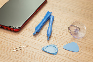 smartphone repair tools on wood table