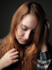 Sad young woman with red hair