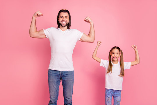 Close up photo beautiful she her little small lady he him his daddy showing muscular hands arms fists one team teamwork winners wear casual white t-shirts denim jeans isolated pink bright background