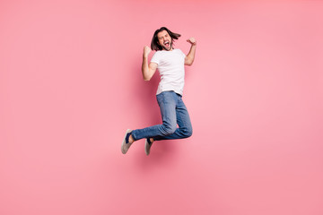 Full length side profile body size photo handsome he him his macho yelling loud jump air raise arms hands excited football competition wear casual white t-shirts denim jeans isolated pink background