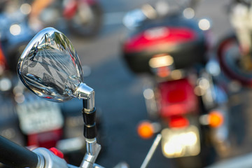Beautiful view of the reflection in the mirror. Beautiful, original background. Motorcycle handlebar. Motorcycle in the background blurred. 