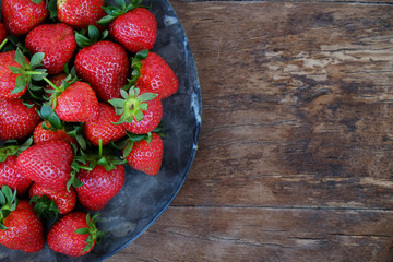 Ripe local produce organic strawberry. Heap of red berries on plate. Fresh healthy vegan dietary food for spring detox. Fruits background, top view. Clean eating concept.