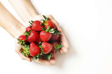 Ripe local produce organic strawberry. Young woman holding heap of red berries in bare hands. Fresh healthy vegan dietary food for spring detox. Fruits background, top view. Clean eating concept.