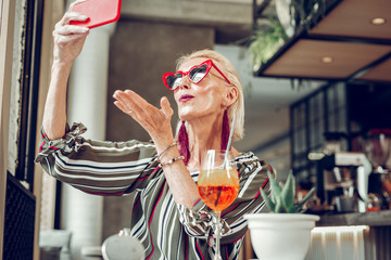 Positive senior woman posing for a selfie