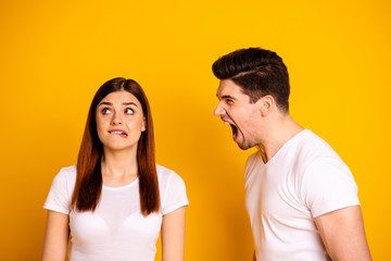 Close up side profile photo two beautiful people she her he him his blame aggression look up frightened fear husband madness mad rage outraged wear casual white t-shirts isolated yellow background