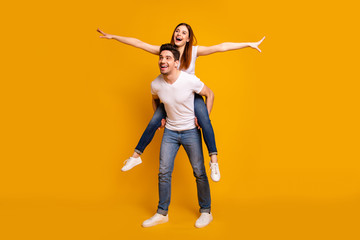 Full length body size view portrait of his he her she two nice attractive playful cheerful optimistic dreamy people wife husband having fun isolated over vivid shine bright yellow background