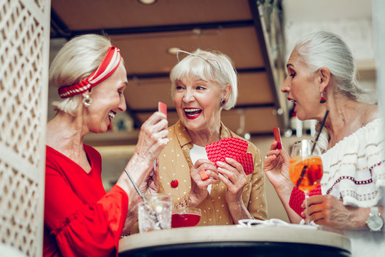 Positive joyful women sitting around the table