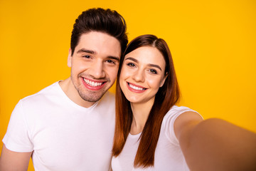 Self-portrait of his he her she two nice attractive lovely sweet charming trendy cheerful cheery people husband wife isolated over vivid shine bright yellow background