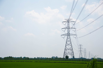 Large high-voltage power poles on the fields, Thailand.