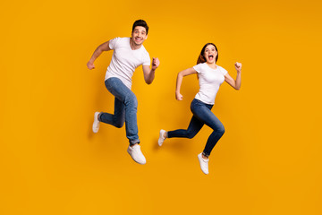 Fototapeta na wymiar Full length side profile body size photo funky funny she her he him his guy lady jump high hurry shopping black friday low prices wear casual jeans denim white t-shirts isolated yellow background