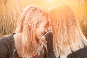 Two happy young woman having fun outdoors at sunset