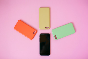 Top view of a smartphone with headphones and charge and silicone cases.