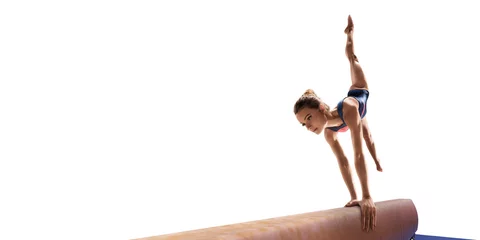 Poster Female athlete doing a complicated exciting trick on gymnastics balance beam on white background. Isolated Girl perform stunt in bright sports clothes © Alex