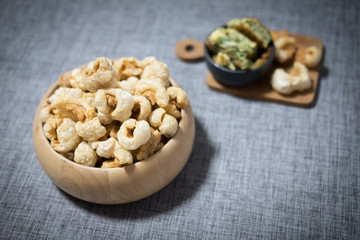 Crispy deep fried pork skin in wooden bowl