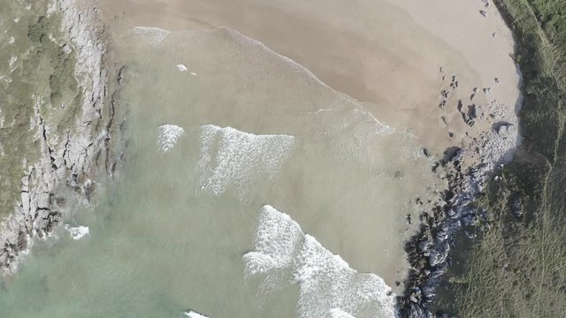 Surfer and tide waves in a beach in Cantabrian sea at dawn #014, Spain - drone aerial 4k footage ungraded (graded version available)