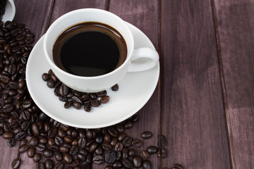 cup of coffee and beans on wooden background