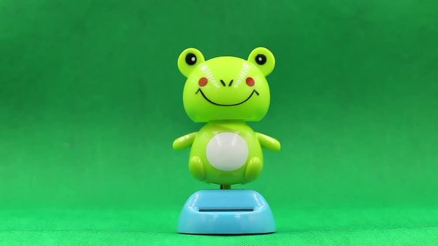 frog solar dancing doll on green background