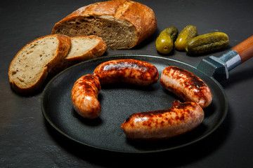 top view four ruddy juicy sausages fried in large frying pan