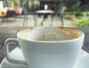 close-up coffee cup on wood table in coffee cafe.