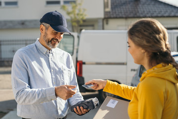 woman paying to a courier with a credit card