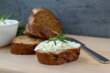 Sliced bread with light cheese on a wooden board.