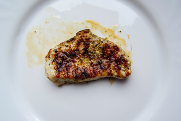 Juicy grilled steak in oil and spices on plate