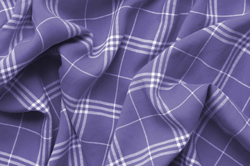 Purple violet checkered plaid clothes material. Close up macro view.Cloth background.Purple and white tartan plaid scottish pattern .