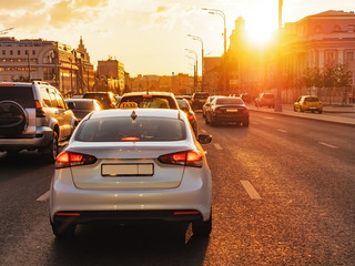 Cars are in a city traffic during a beautiful golden sunset in a Moscow.