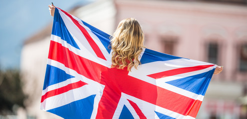 Attractive happy young girl with the flag of the Great Britain