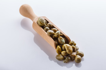 Pickled capers on a white acrylic background