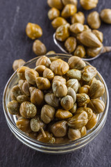 pickled capers on a dark stone background