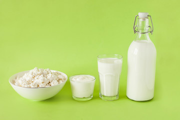 Milk kefir sour cream and cottage cheese are in a row on a green background. Fresh dairy products for breakfast
