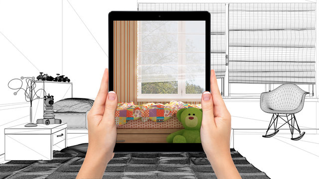 Hands holding tablet showing colored kids bedroom. Blueprint CAD sketch background, augmented reality concept, application to simulate furniture and interior design products