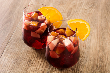 Red wine sangria in glass on wooden table. 