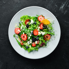 Salad. Salad of arugula, blue cheese, strawberries and blueberries. Top view.