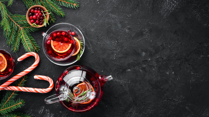 Hot tea with berry cranberry and orange. On the black kitchen background. Top view. Free space for your text. - Powered by Adobe