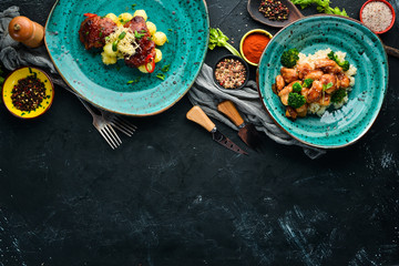 Dishes of Chicken with Potatoes and Rice. In the plate. Top view. Free space for your text. Rustic style.