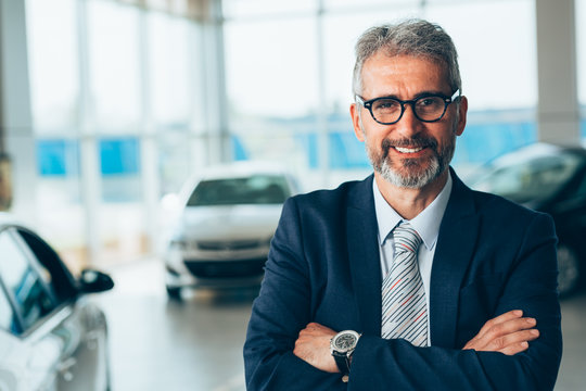 manager crossed arms in car showroom