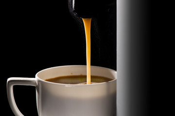 Hot coffee flow to a cup on espresso machine.