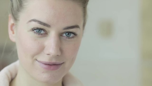 Portrait of a beautiful blonde European woman with blue eyes smiling at the camera with copy space on the right