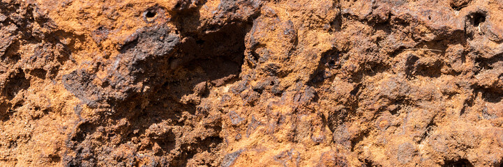 Natural volcanic stone in red and brown. Surface of the volcanic rock. Panoramic image
