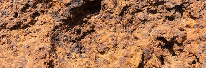 Natural volcanic stone in red and brown. Surface of the volcanic rock. Panoramic image
